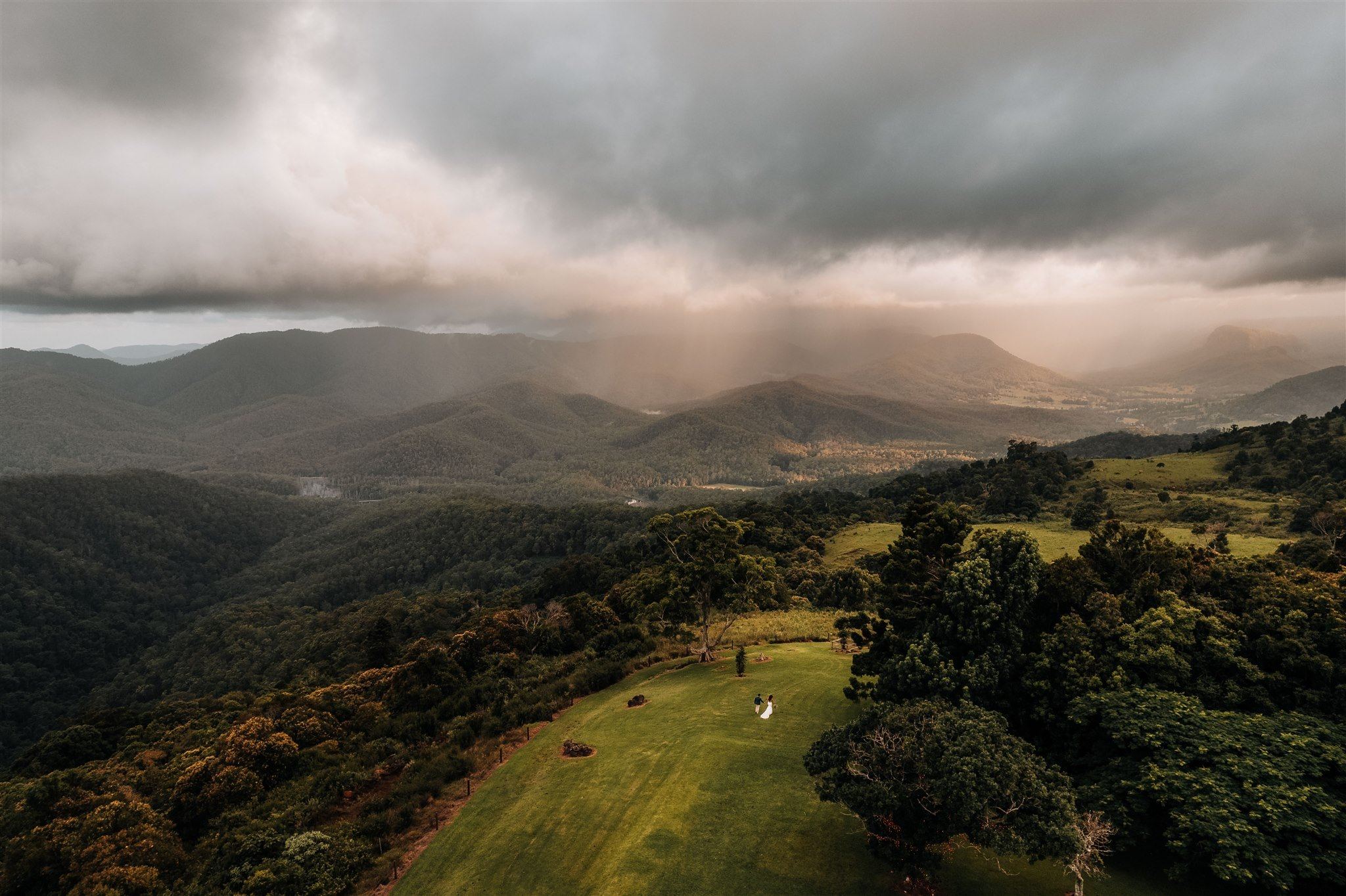 Aerial view of Rosewood Estate under storm light, the ranges beyond