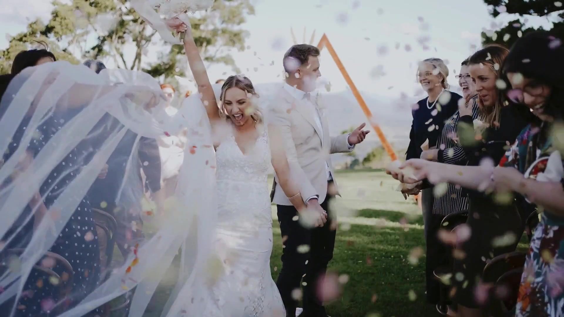 Newlyweds walking through a shower of confetti at Rosewood Estate