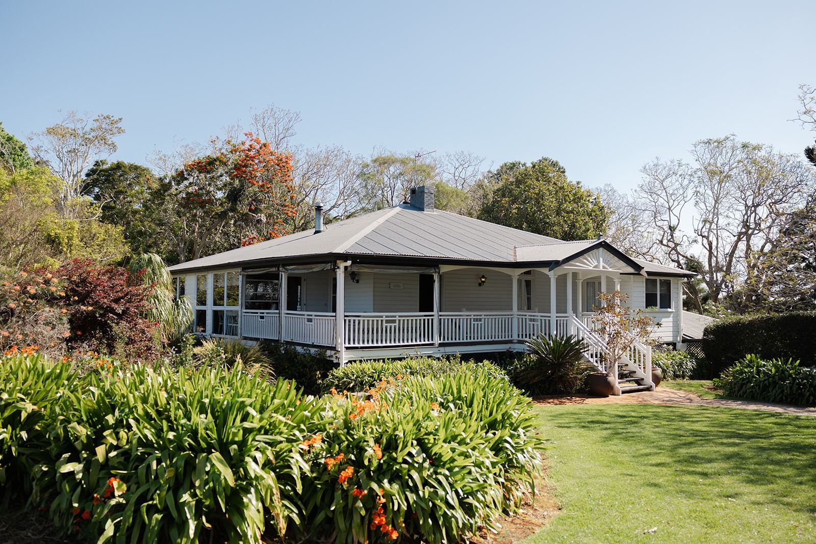The homestead behind flowering garden beds