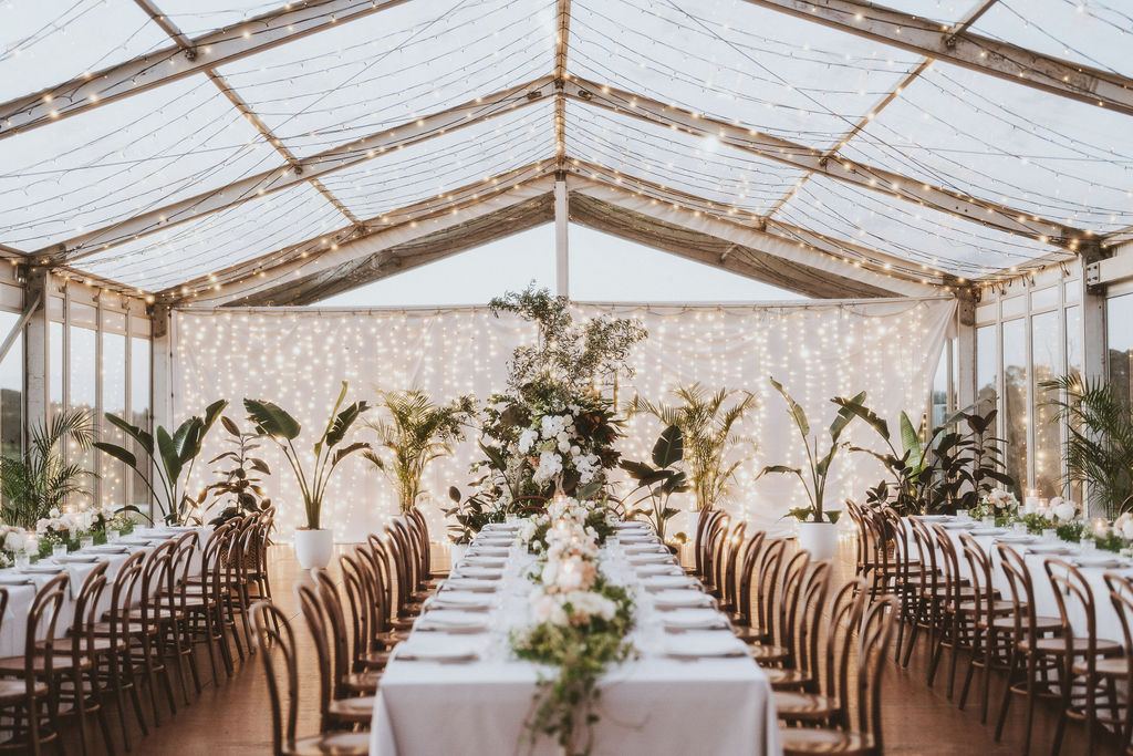 The marquee styled with greenery and long tables