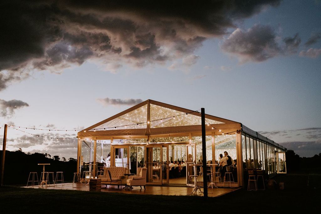 The marquee lit up under a stormy evening sky