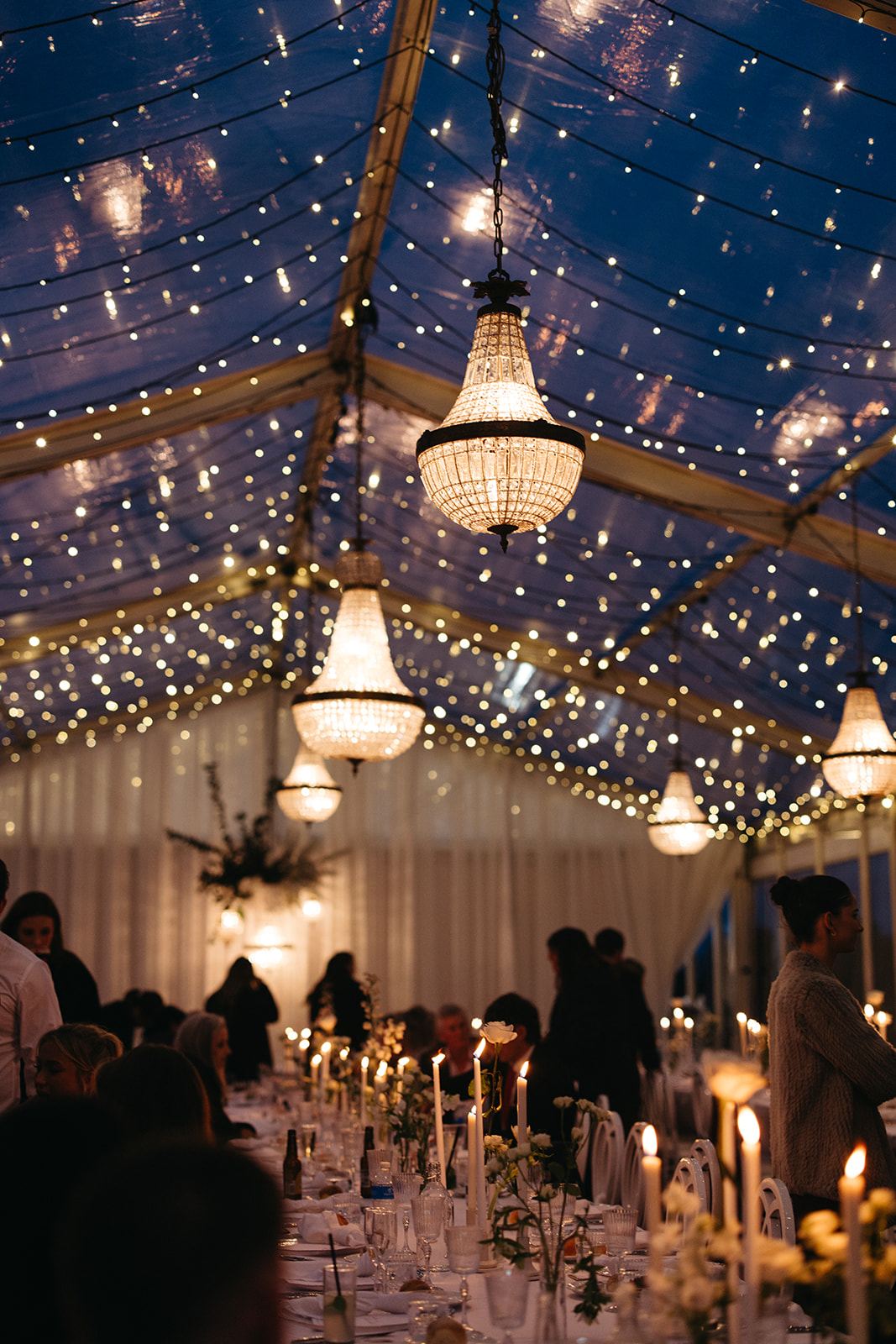 Inside the marquee at night with chandeliers