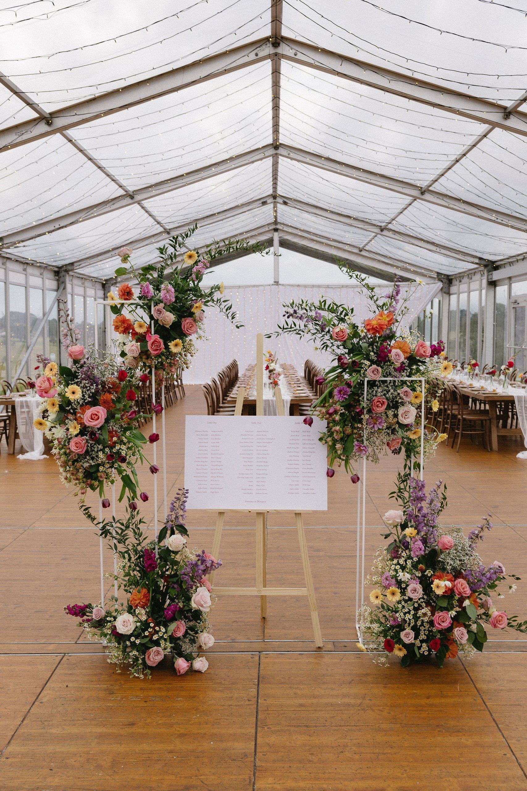 Floral installations under the marquee's white summer roof